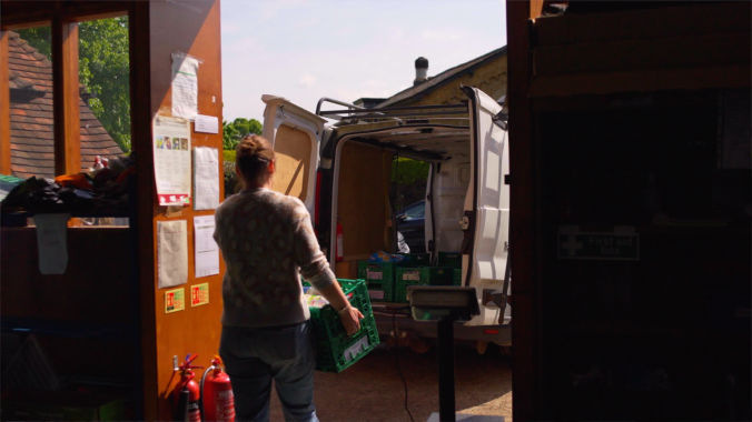 Volunteer sorting food donations at a food bank during a charity video production