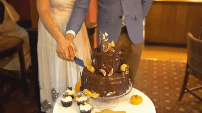 cutting cake whilst being filmed by wedding videographer Portugal